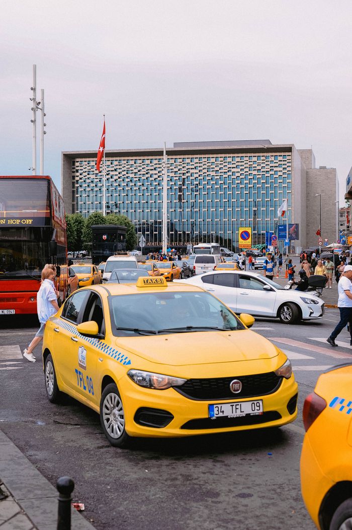 Services Yellow taxis and bustling street scene in front of a modern building in Istanbul, Turkey.