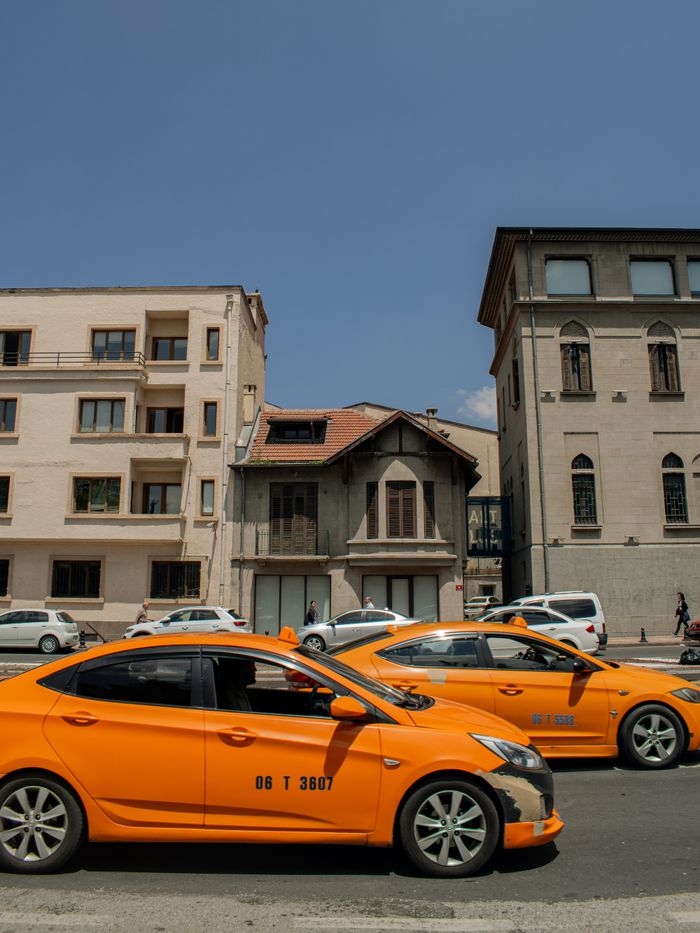 Services Street view of yellow taxis in front of historic buildings under clear blue sky.
